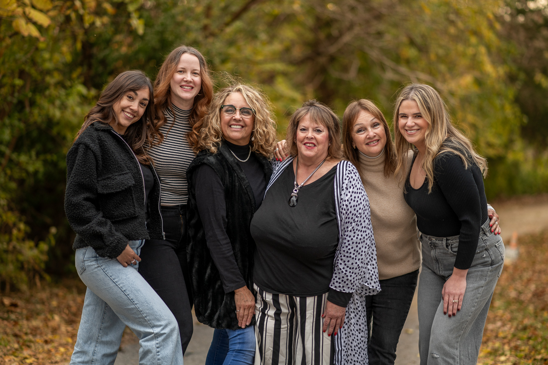 Family group smiling during an outdoor fall photography session in St. Joseph, Missouri with autumn colors.