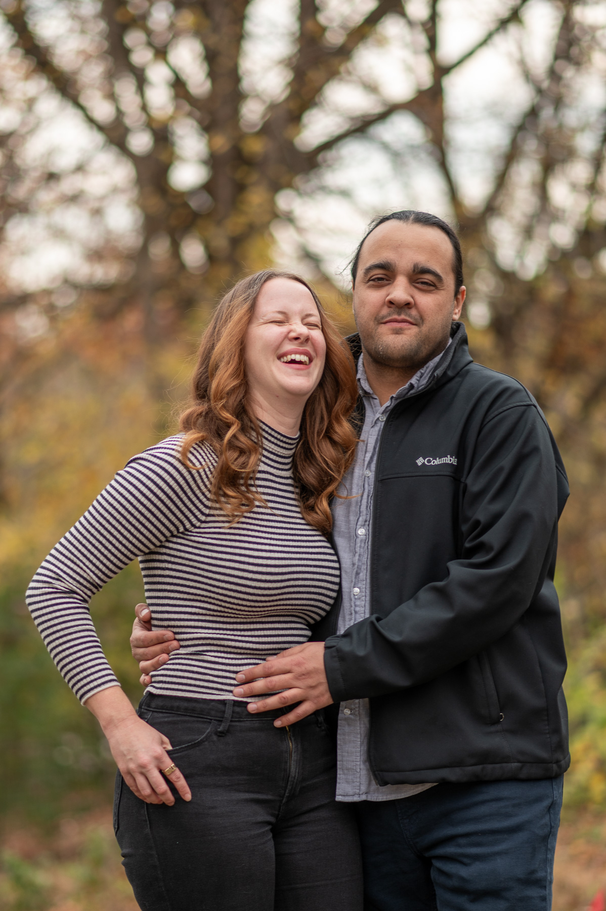 Candid autumn portrait of a couple laughing together in St. Joseph, Missouri during fall season.